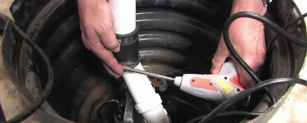 Sump pump installation technician connecting PVC discharge piping in Phoenix, AZ