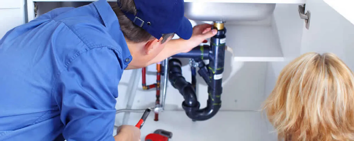 Plumber repairing under-sink drain pipes and fittings in Phoenix, AZ